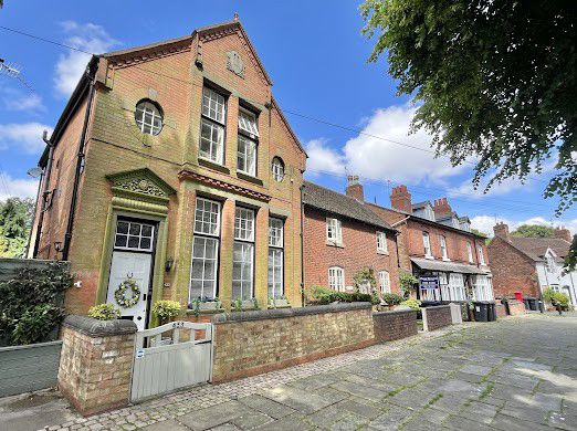 row of old buildings photographed at street level against summery blue sky
